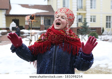 shrovetide party, woman in national costume singin on the winter mansion background