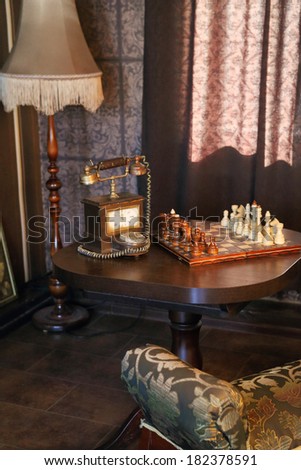 retro room interior with wooden chess pendulum wall clock and dial phone