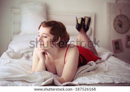 beautiful plump young woman in pin up style laying on the bed