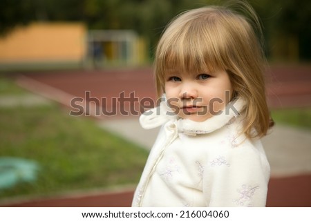 cute little blond girl in the kinder garden yard