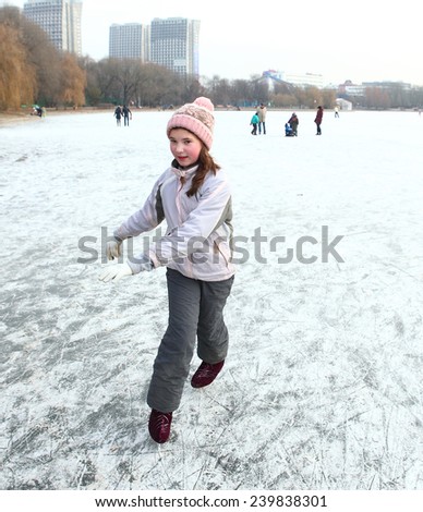 beautiful happy preteen girl figure skating in open winter skating rink