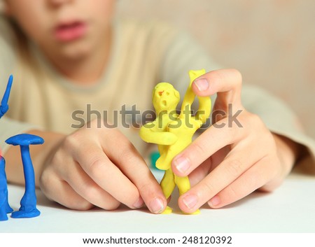 boy hands making rock group musician from modeling clay