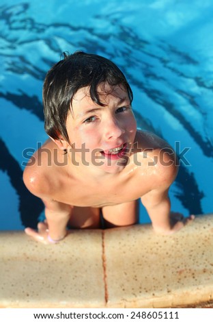 preteen little boy in open air swimming pool