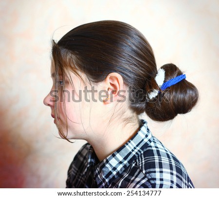 cute preteen girl with beautiful dark hair bun close up photo