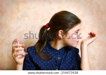 preteen cute  girl with long dark hair in pony tail smell new perfume