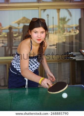 preteen beautiful girl play table tennis in the beach resort hotel recreation area