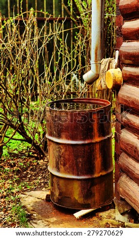 house drain pipe and rusted barrel on the corner of the block country house