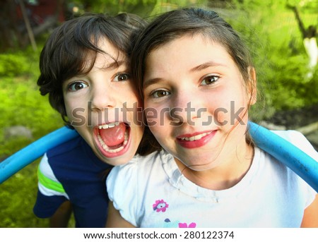 siblings preteen boy and girl together close up portrait on the summer green background siblings preteen boy and girl together close up portrait on the summer green background