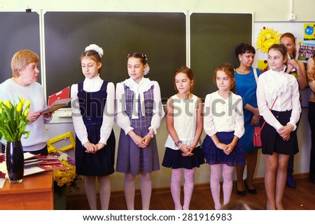 MOSCOW, MAY 26, 2015: Graduation in the primary school in Moscow, May 26. Graduating girls with their teacher  gets diploma and then go to the middle school.