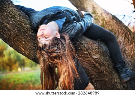 beautiful teenager girl with long blond hair climb tree
