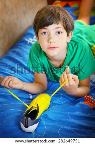 teen handsome boy with brand new yellow football boots close up photo