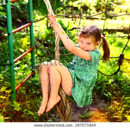 pretty blond girl swinging on the outdoor summer play ground