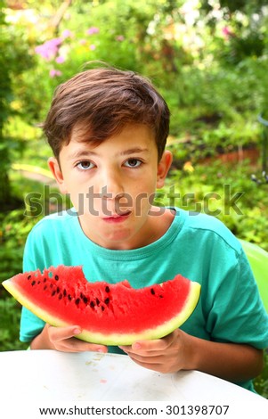 cute handsome boy with water melon slice on summer garden background