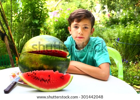 cute handsome  boy with water melon slice on summer garden background