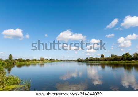 River with blue sky and clouds reflected in water in summer day