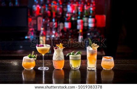 alcohol cocktails standing on the bar in row, night club scenery
