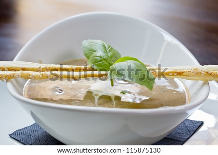 delicious mushroom soup with sesame sticks and basil leaf