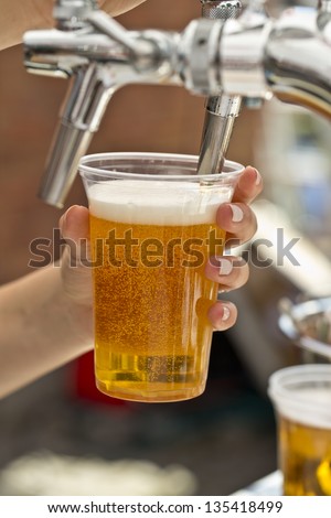 pouring a plastic glass of beer
