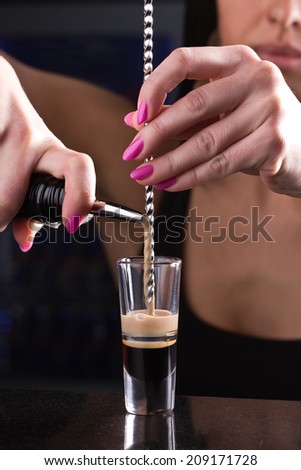 beautiful barmaid preparing alcohol shots