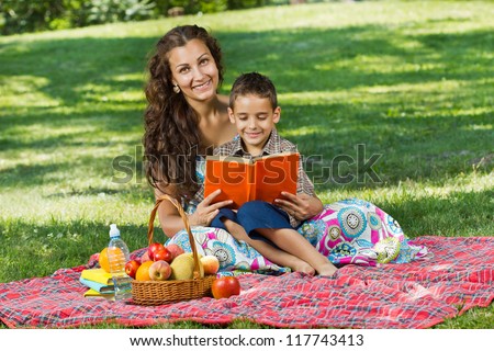beautiful mother and little boy reading book together
