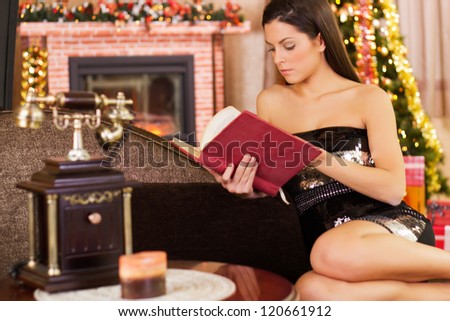 beautiful woman at Christmas night reading a book