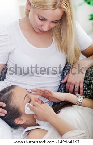 Friend comforting her crying friend at home