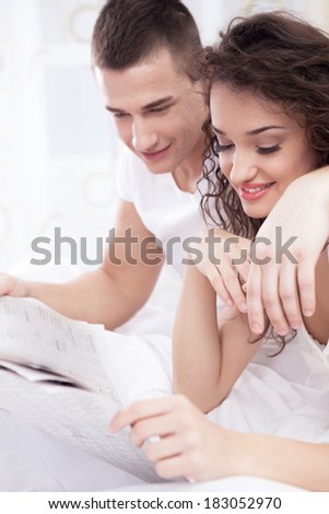 couple in bed reading a newspaper