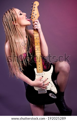 attractive punk girl with lots of tattoos and electric guitar
