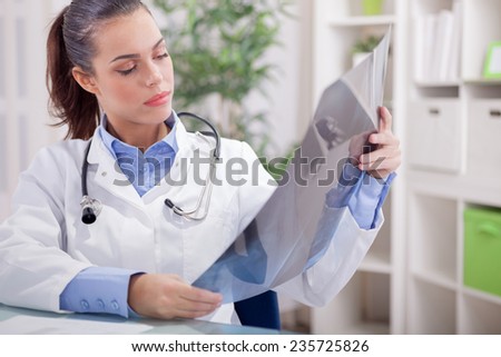 young female radiologist  looking at x-ray
