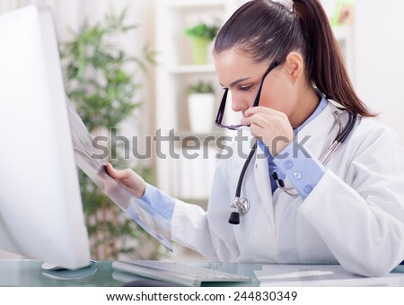 young female radiologist  looking at x-ray
