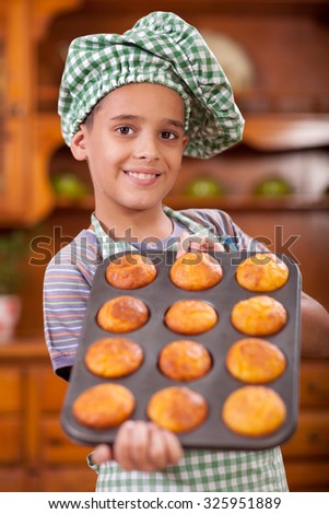 happy smiling young boy chef in kitchen