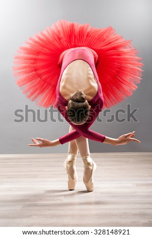 Ballerina is wearing a red tutu and pointe shoes