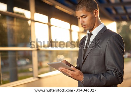 Successful business man with digital tablet outside