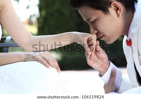Asian groom kiss to his bride\'s hand