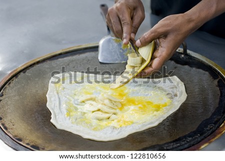 Southern flat bread cooking with egg and banana, food.