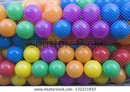 Colour plastic balls in package. Plastic mesh bags.