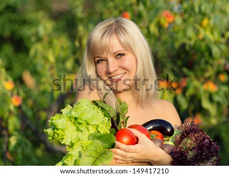 portrait of beautiful smiling girl with vegetables and herbs on green background