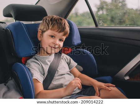 little boy sitting in safety car seat