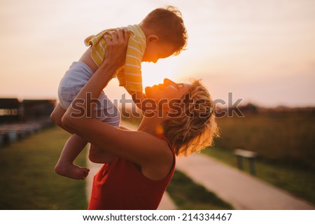 Silhouette of a young mother and her little son at sunset