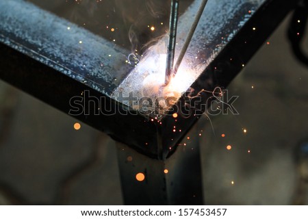 worker with welding metal and sparks  welding with sparks