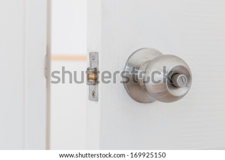 Detail of a metallic knob on white door , tainless steel round ball door knob