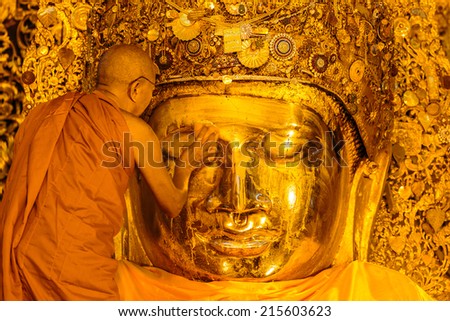 MANDALAY-AUGUST 26: The senior monk wash Mahamuni Buddha image in ritual of the Buddha image face wash on August  26, 2014 at Mahamuni temple in Mandalay, Myanmar.This ritual commences every morning