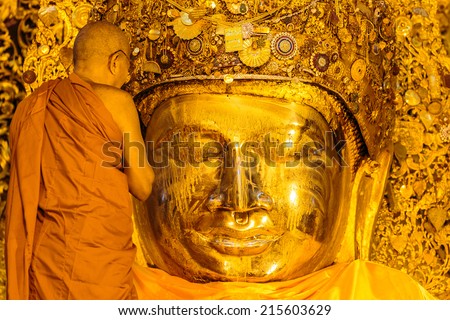 MANDALAY-AUGUST 26: The senior monk wash Mahamuni Buddha image in ritual of the Buddha image face wash on August  26, 2014 at Mahamuni temple in Mandalay, Myanmar.This ritual commences every morning