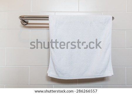 Bathroom Towel - white towel on a hanger prepared to use