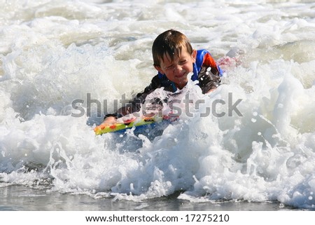 Boy using a body board in the middle of a wave
