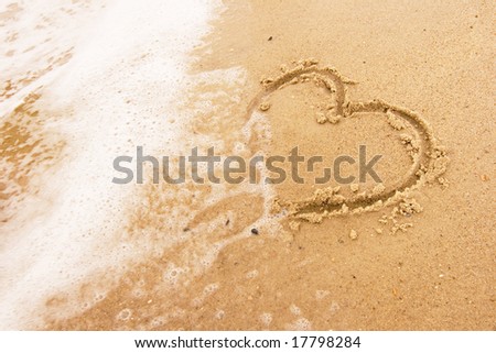 Heart in the sand being washed away