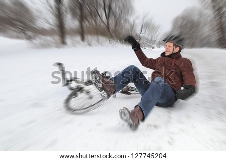 Bicycle accident on a snowy street with a falling man