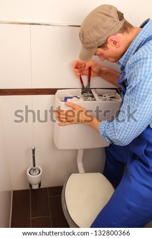 Young craftsman repairing Toilet