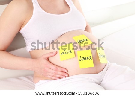 A Pregnant woman with girls names on her baby belly