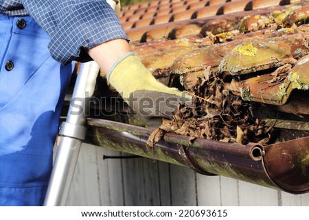 Man Cleaning a rain gutter in Close up